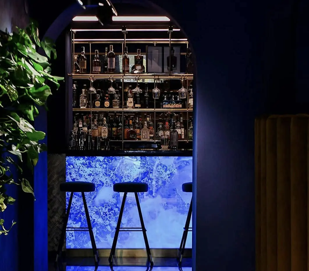 Bar intimista com balcão Pelle retroiluminado em azul